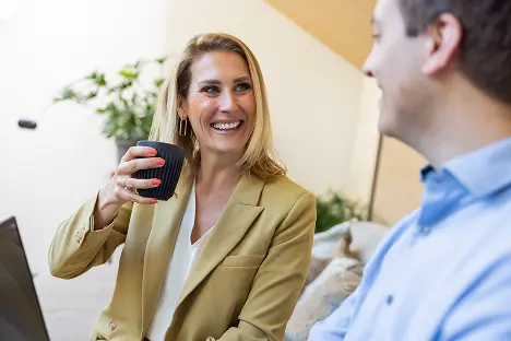 Adviseur met koffie in gesprek met een klant