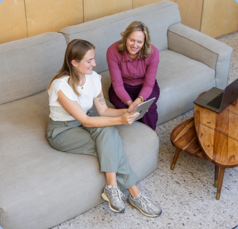 Twee collega's bekijken samen cijfers op een tablet